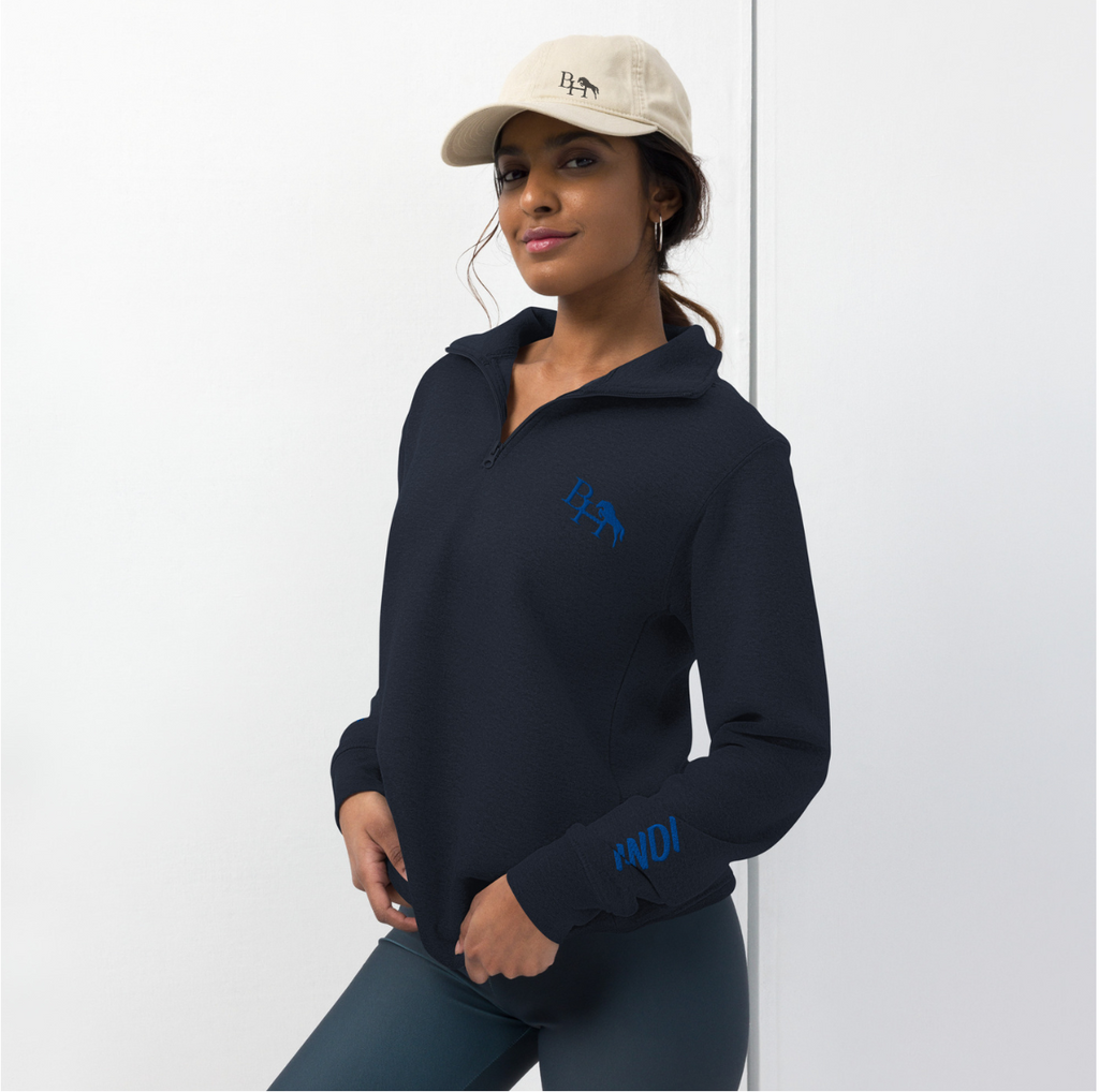 Person wearing a navy blue hoodie with a logo, standing against a white background